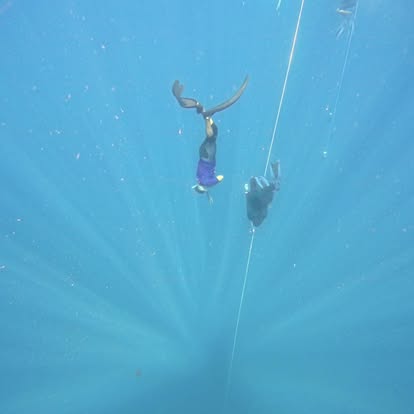Freedivers descending along the line