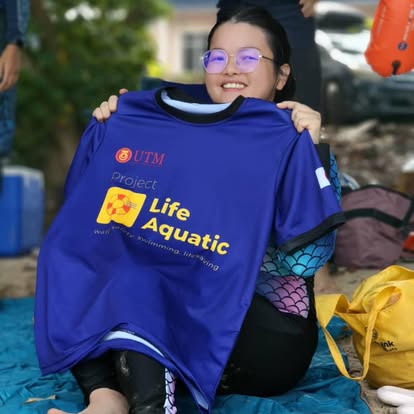 Volunteer holding up the Project Life Aquatic jersey