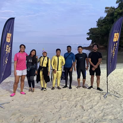 Wetsuit divers beside the project banners