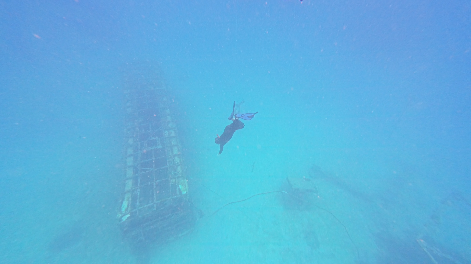 Freediver gliding above a sunken wreck